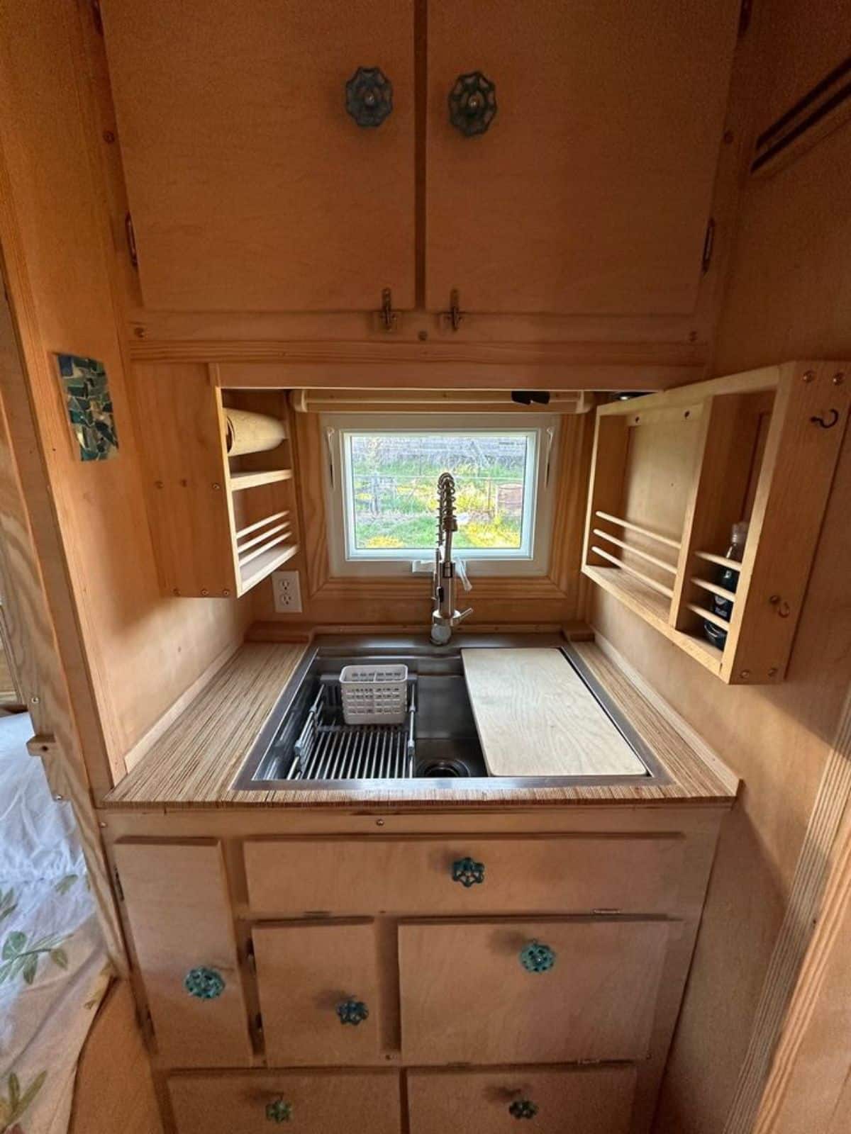 stainless steel sink with storage cabinets on opposite side of kitchen in rare custom built tiny home