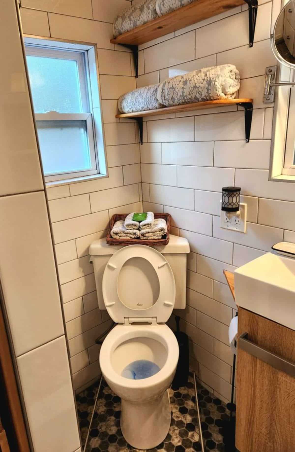 standard toilet installed in bathroom of rustic mini home