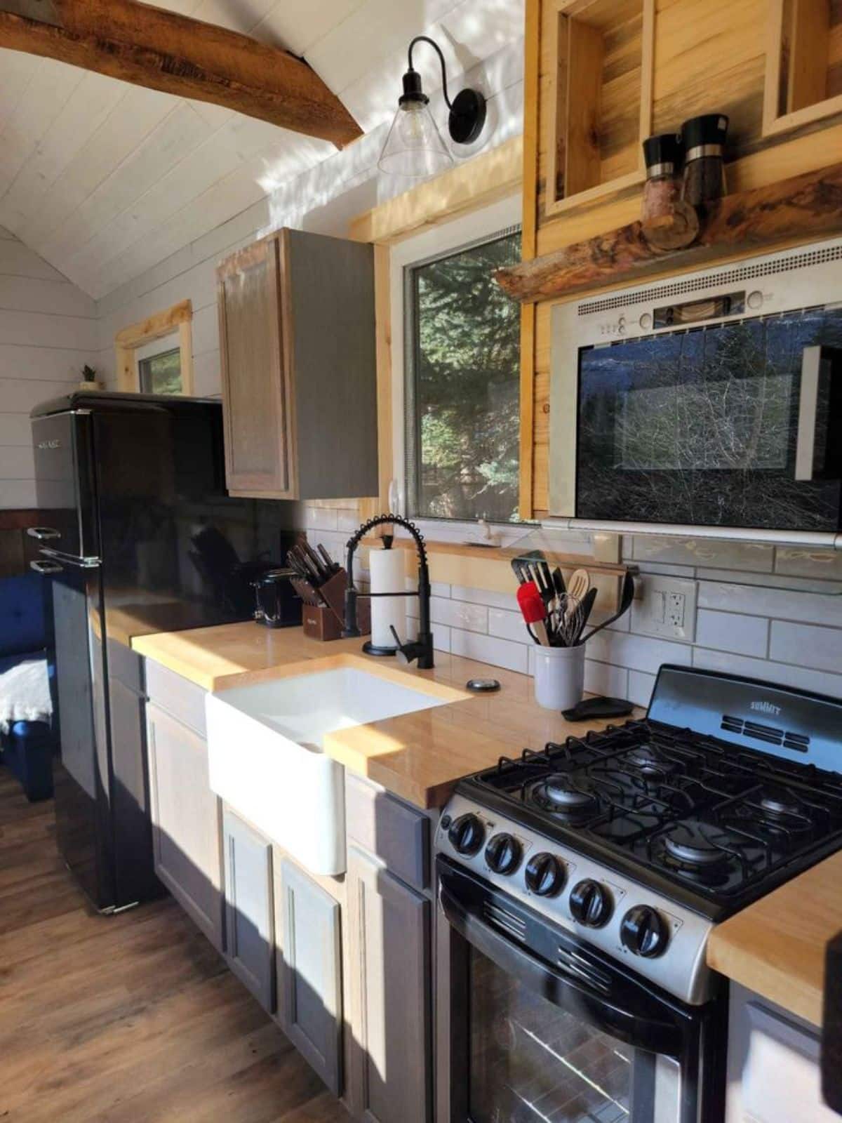 huge countertop with sink and double door refrigerator in the kitchen area of 1 bedroom tiny house