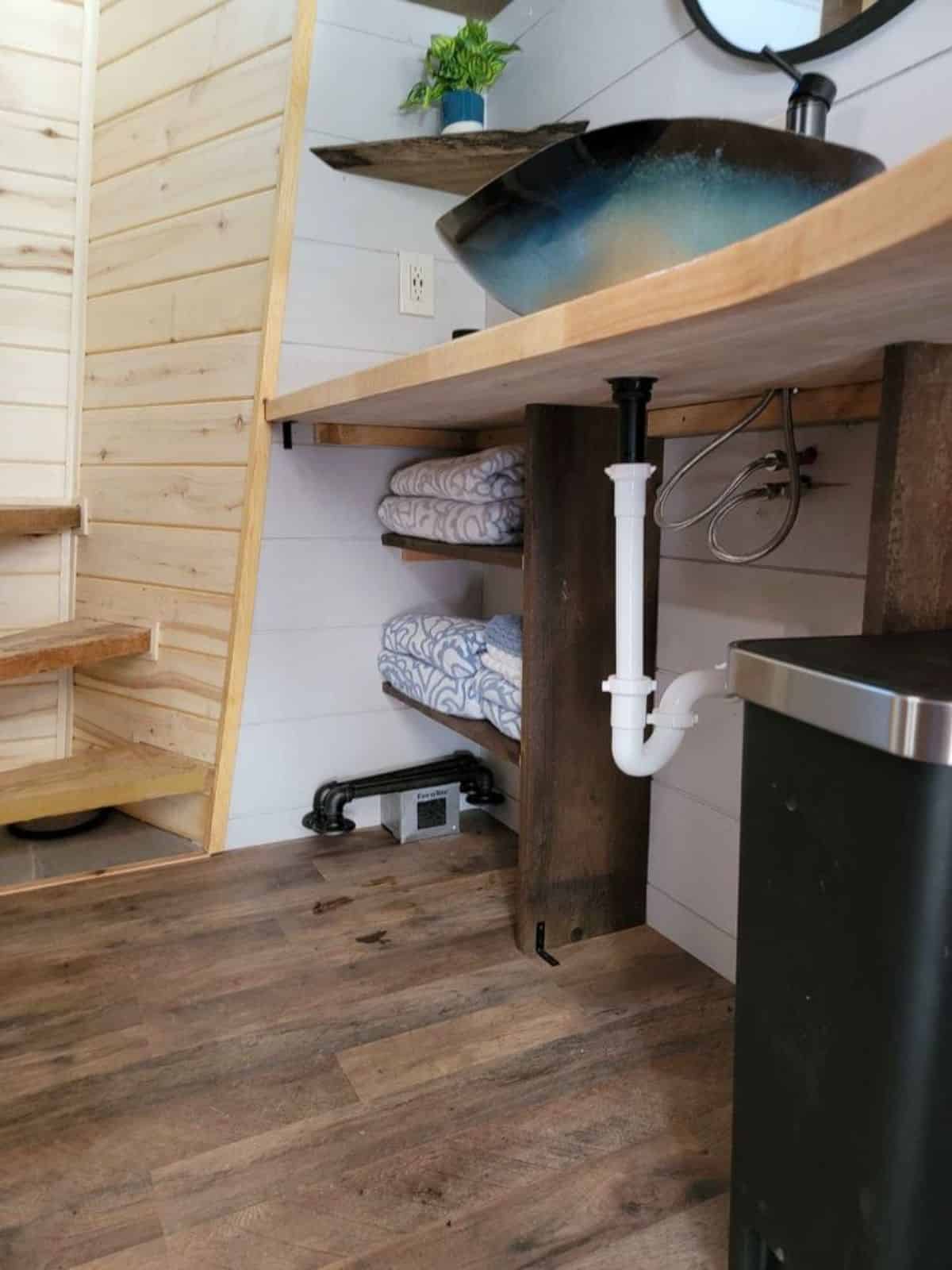 sink with mirror and separate place for washer and dryer combo in bathroom of 1 bedroom tiny house