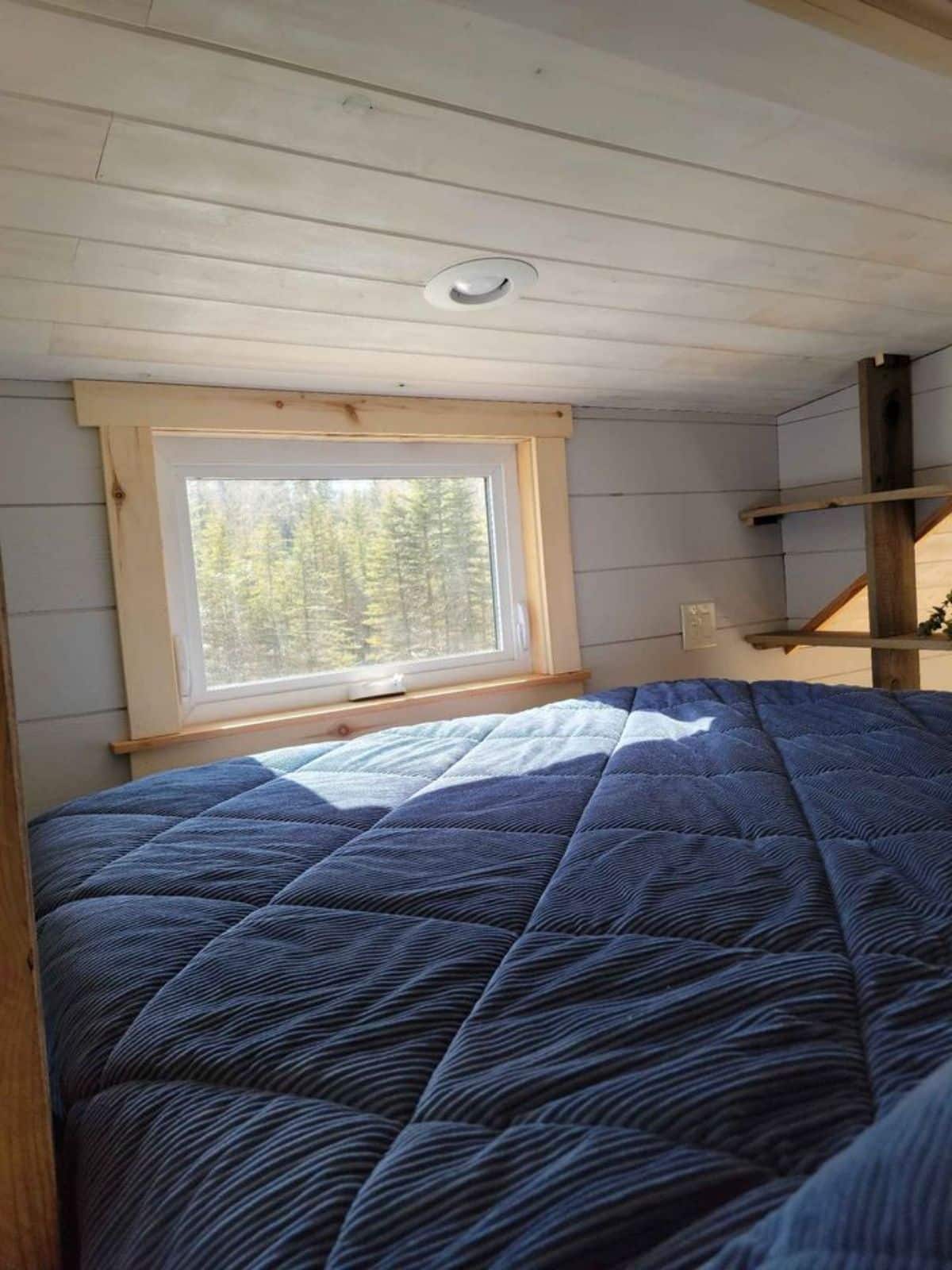 comfortable mattress with huge window on loft of 1 bedroom tiny house