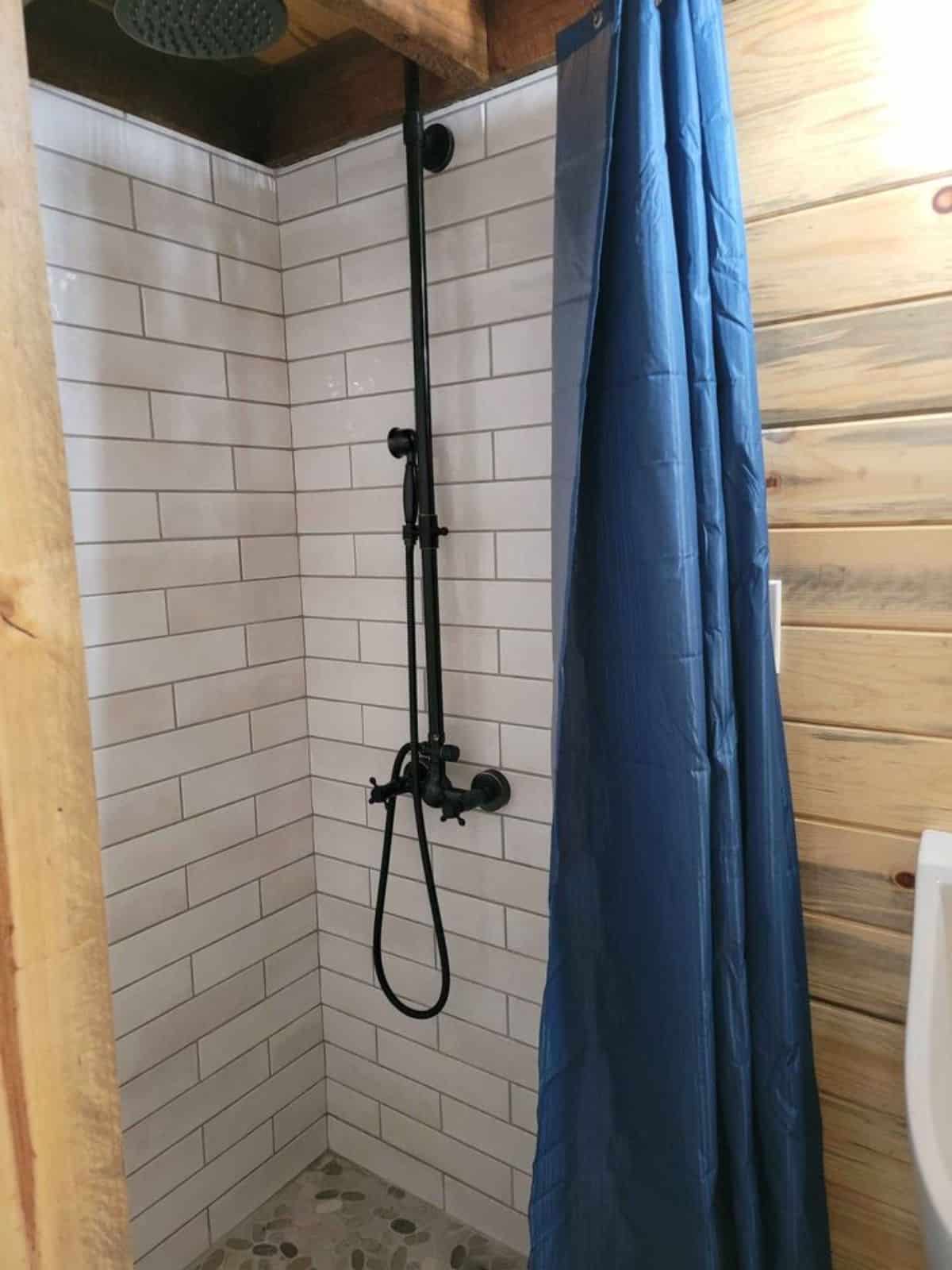 full length tiled shower area in bathroom of 1 bedroom tiny house