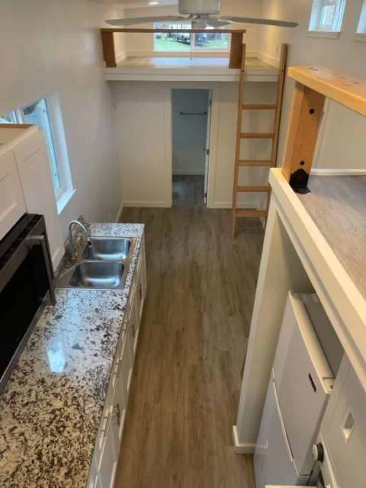 huge countertop in kitchen area of tiny home with a loft