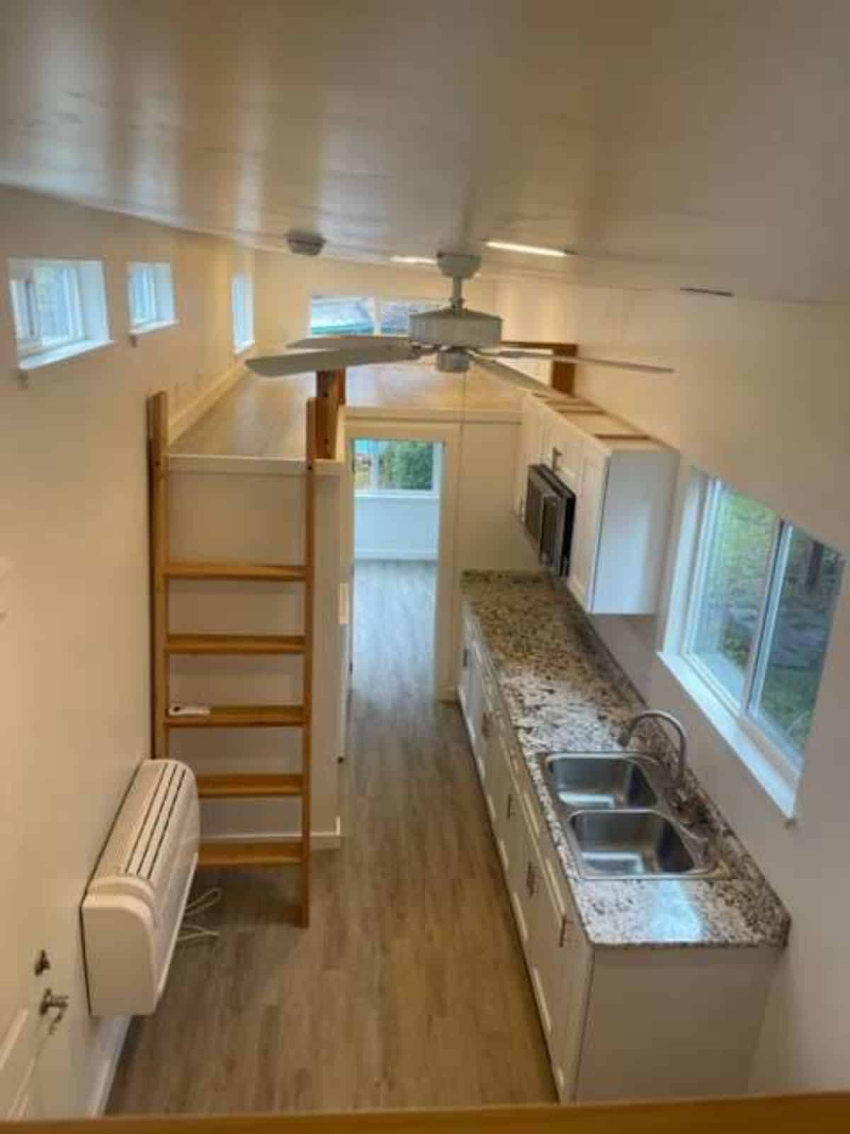 full length interiors of tiny home with a loft