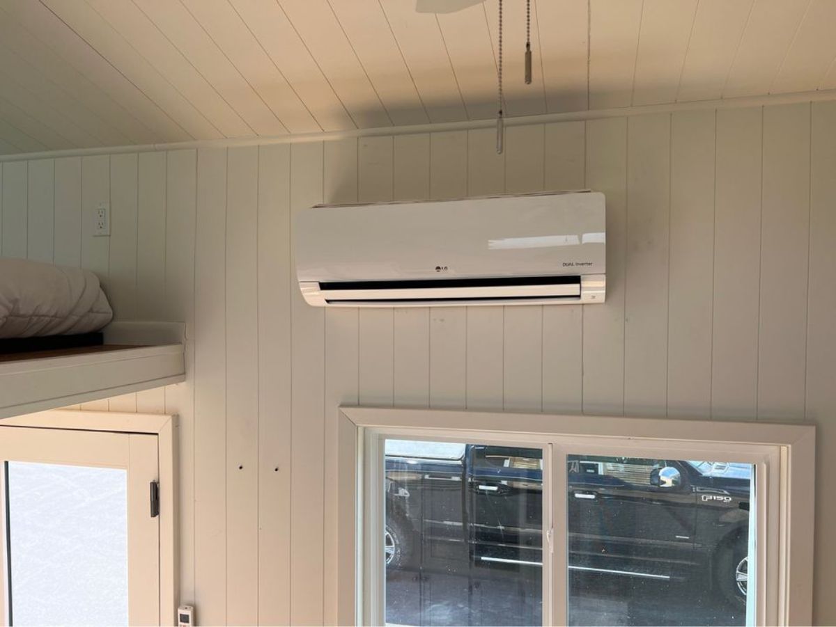 split air condition unit installed above the main door of tiny double lofted home