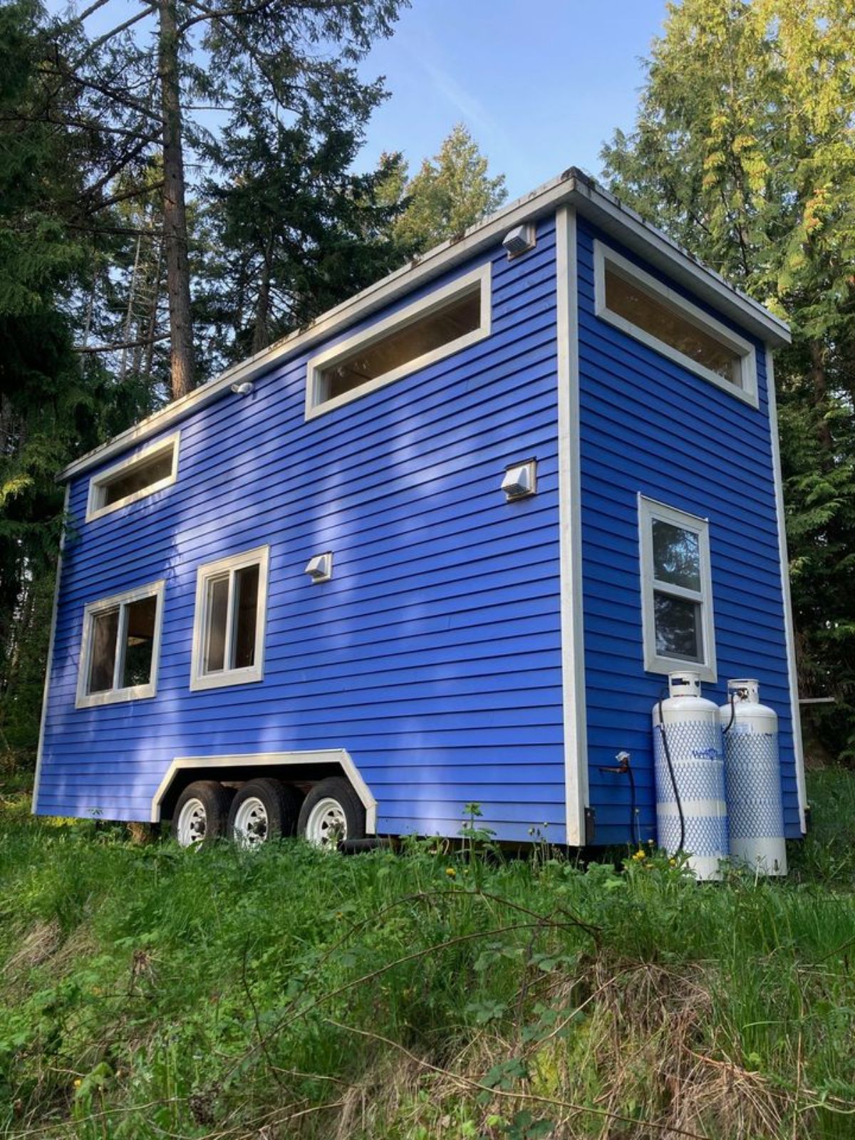 stunning blue exterior of 24’ custom tiny home
