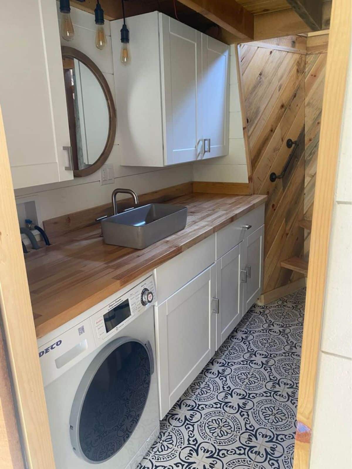 full length sink with vanity and mirror with washer dryer combo in bathroom of 24’ NOAH certified tiny house