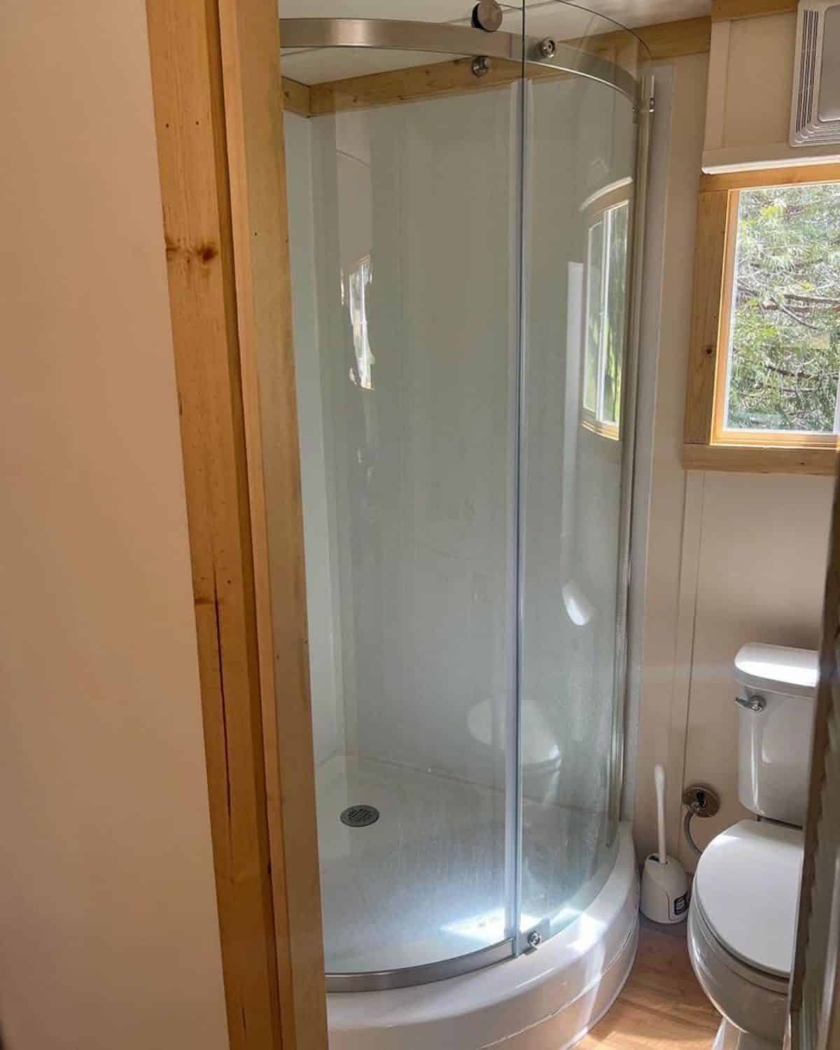 full length shower area with glass enclosure in bathroom of 30’ budget dwelling