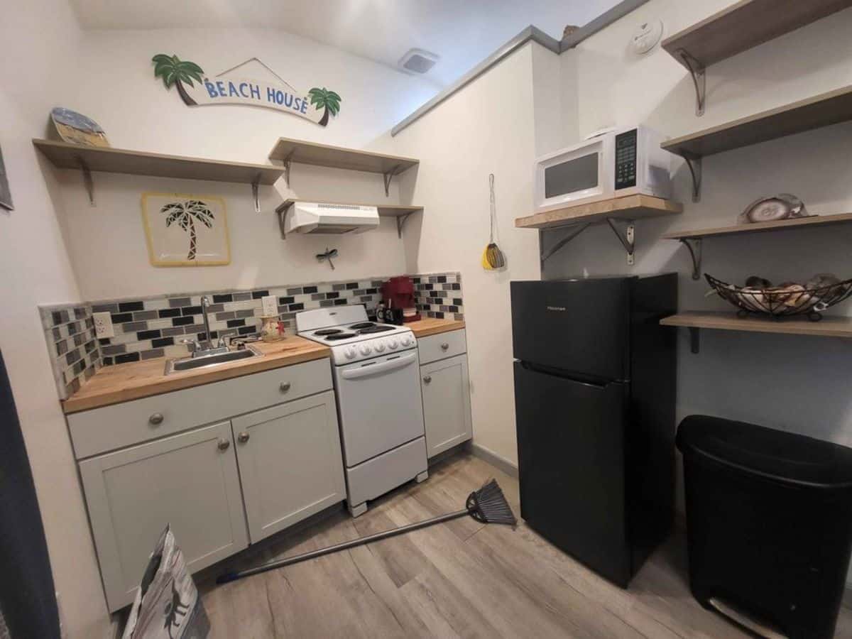 dedicated and well organized kitchen space with countertop, necessary appliances of spacious tiny house