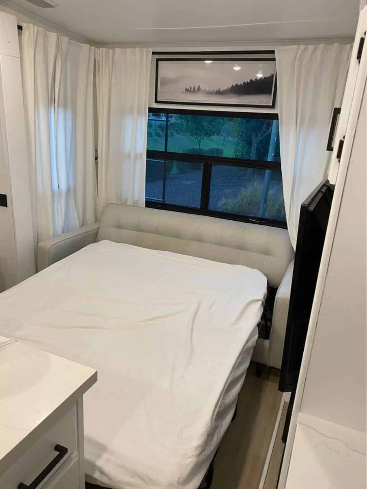 huge comfortable bed in bedroom of 40' renovated tiny home