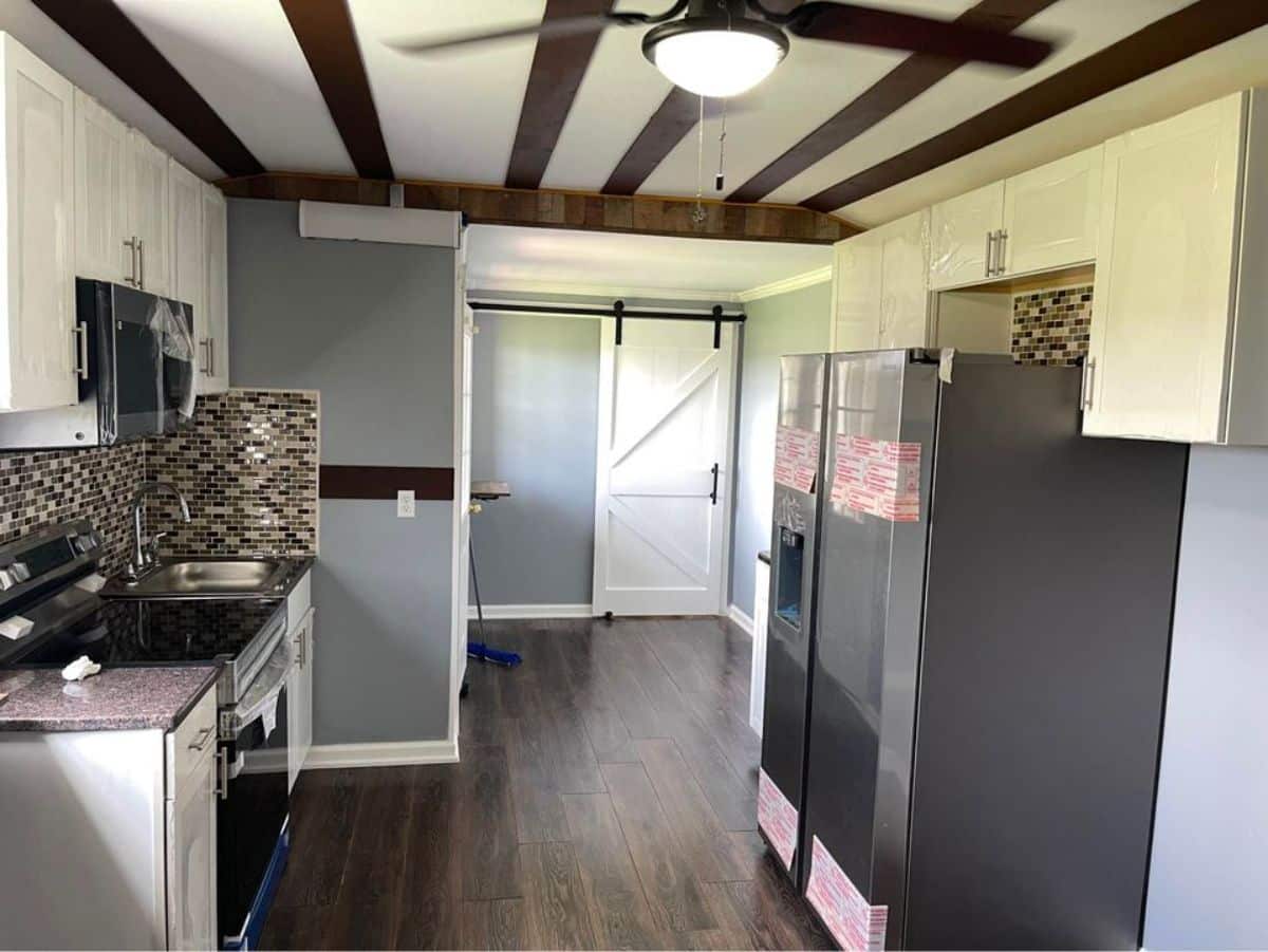 full length kitchen and living area of beautiful tiny home