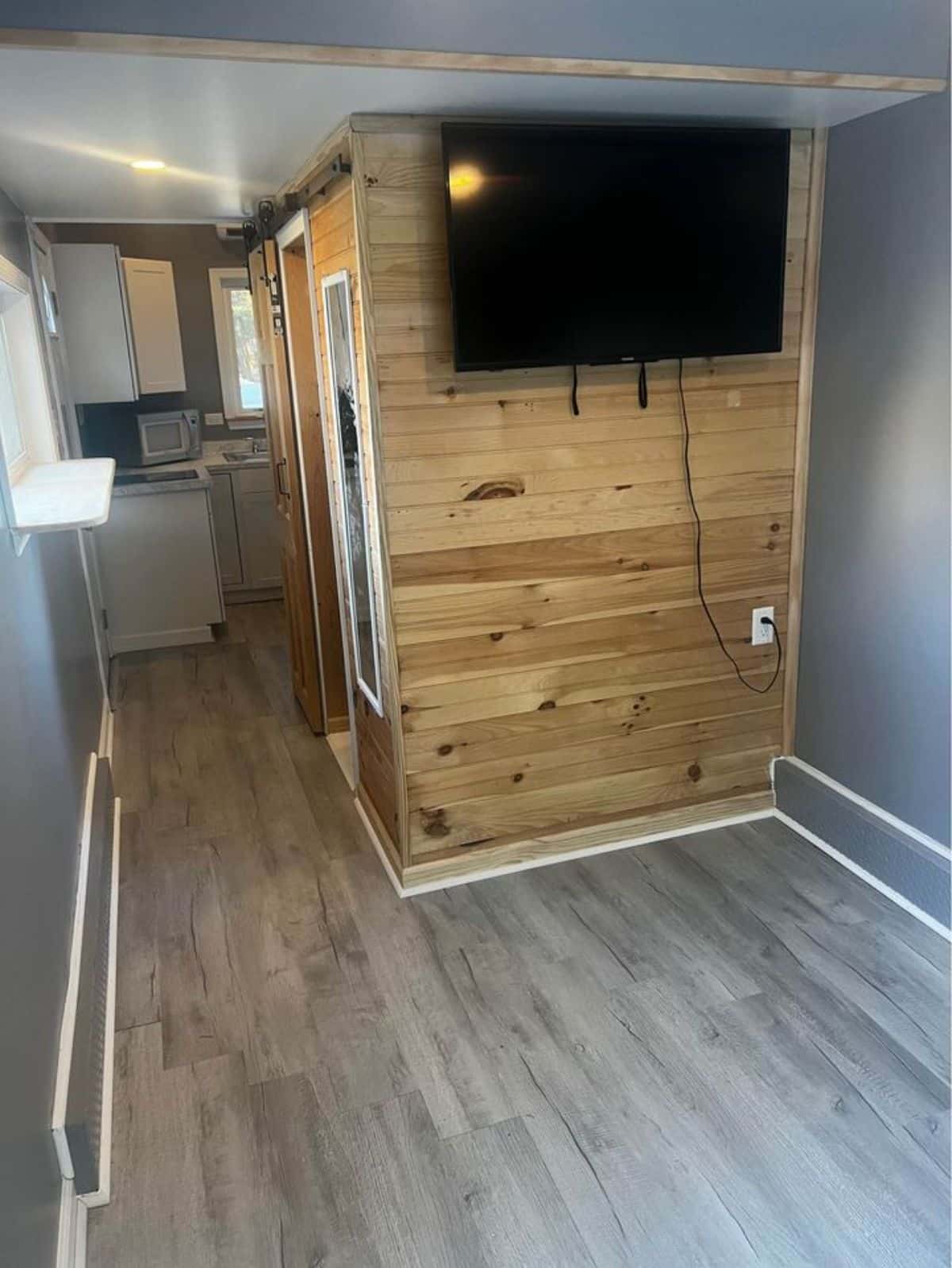 wall mounted TV set in living area of custom tiny house