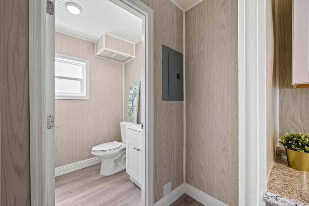 bathroom of brand-new tiny home has standard toilet and sink with vanity and still left with ample space