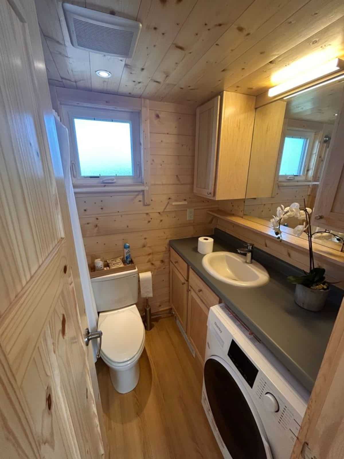 bathroom of certified tiny home has all the standard fittings with washer dryer combo