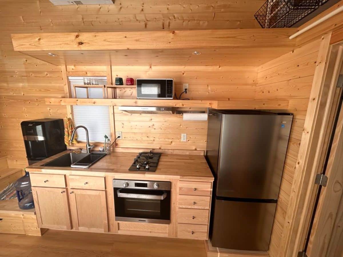 long kitchen countertop with lots of appliances in kitchen area of certified tiny home