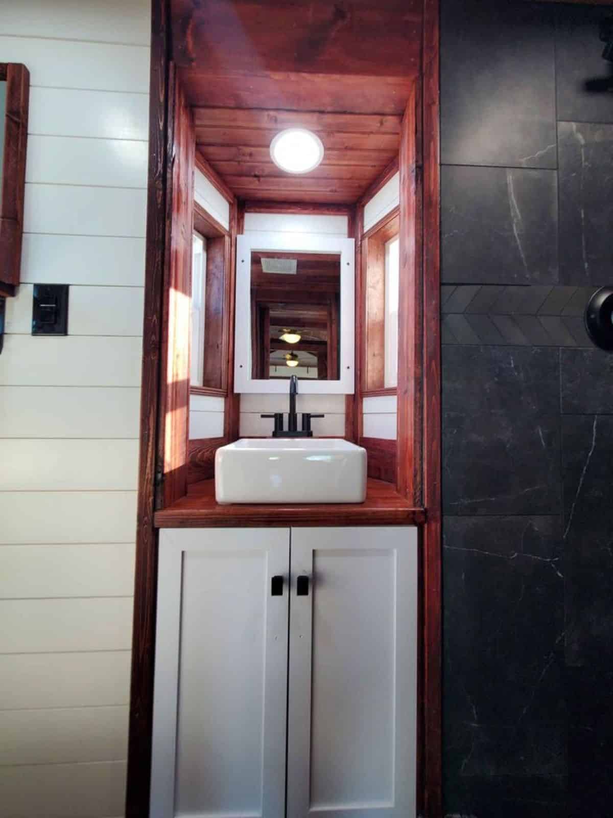 sink with vanity and mirror and standard toilet in bathroom