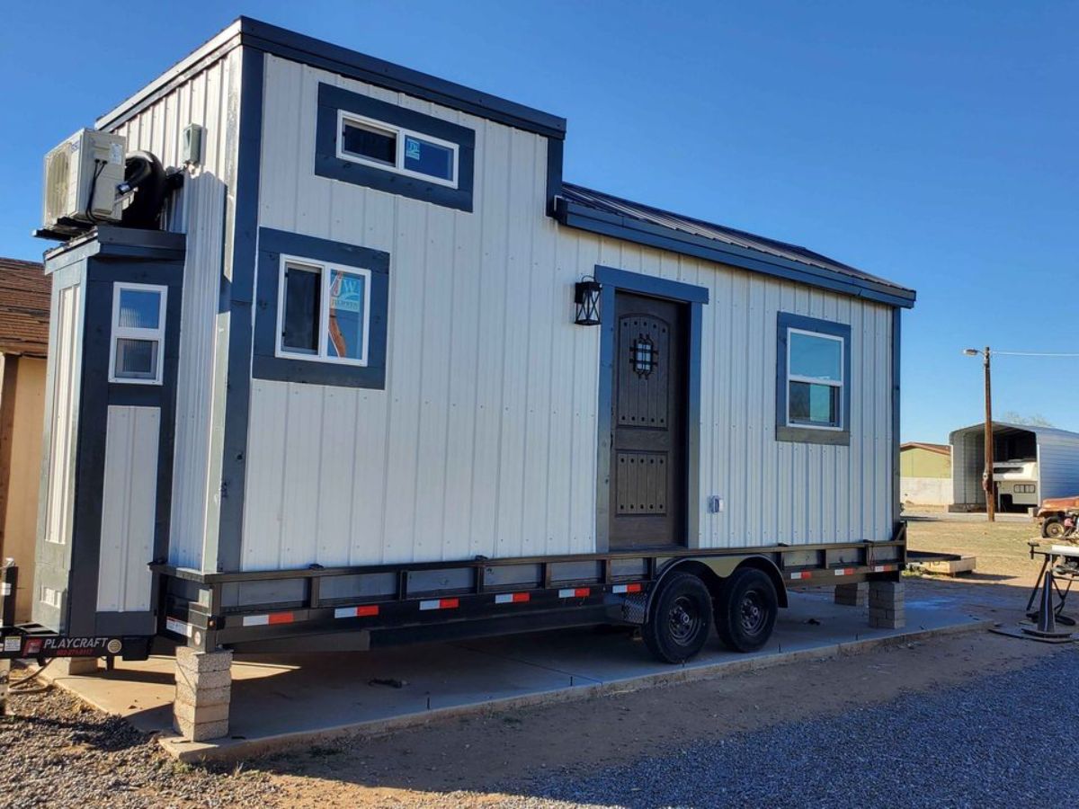 main entrance and stunning white exterior of 24' tiny home on wheels