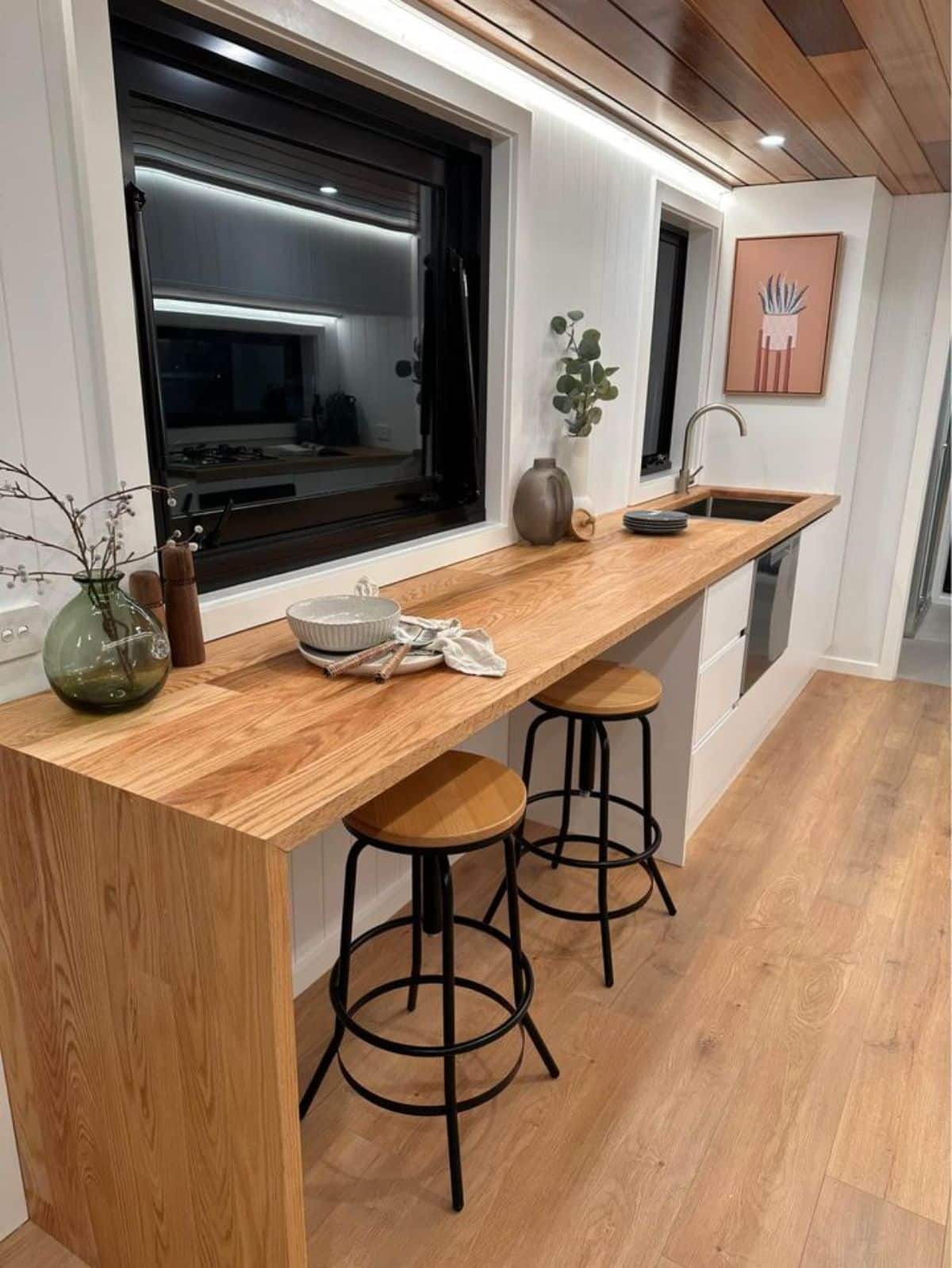 full length countertop and sink with dining table and chairs