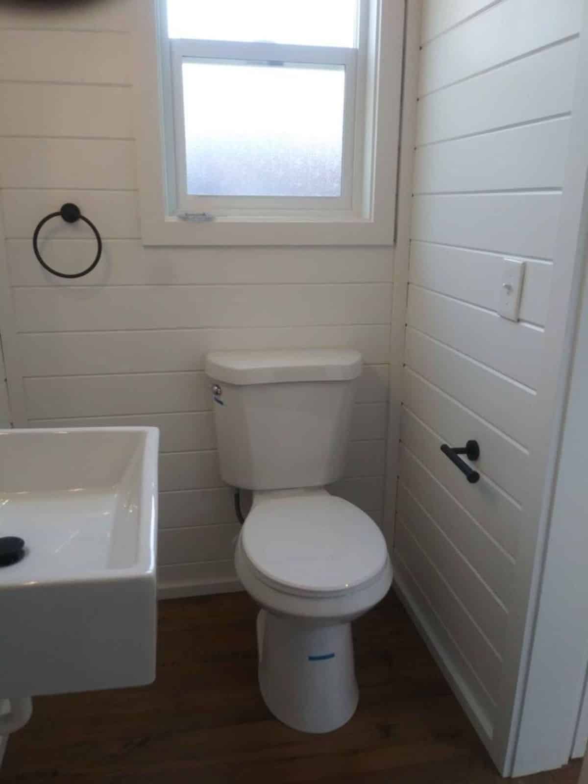 standard toilet with storage cabinets in bathroom