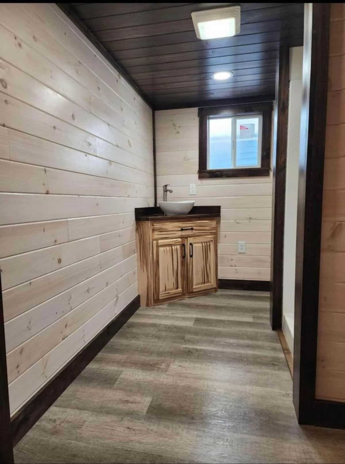 wooden floor and walls of spacious tiny home