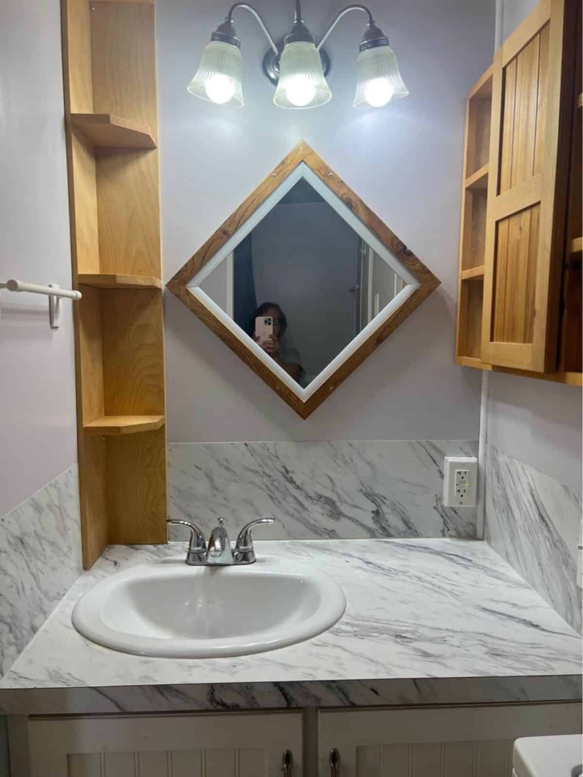 sink with vanity and mirror in bathroom of 2 bedroom tiny house