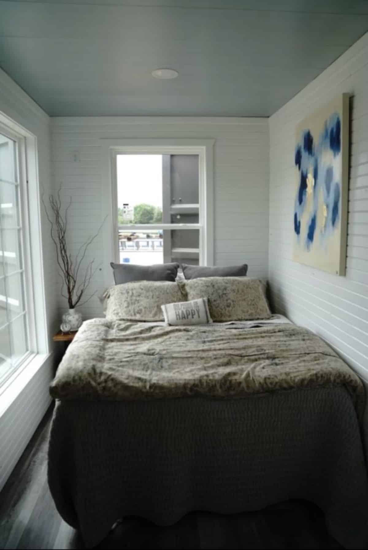 bedroom is on the end of the custom built container home with comfortable bed