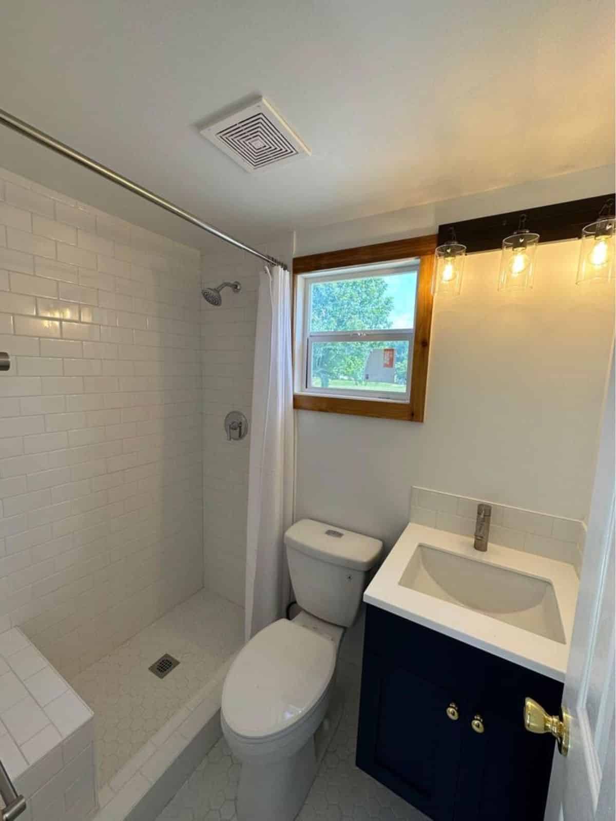 bathroom of stunning tiny home has all the standard fittings