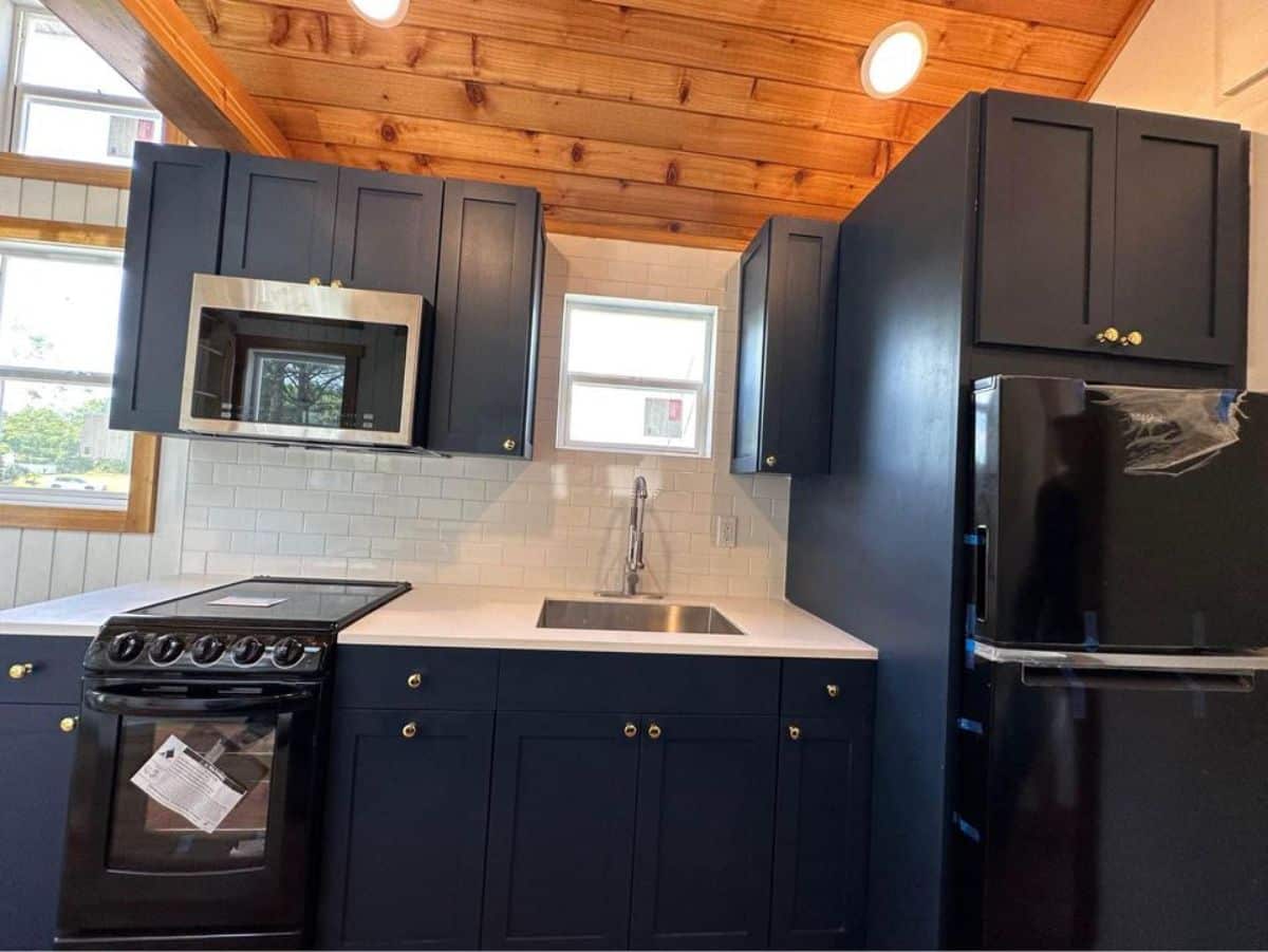 stunning kitchen countertop with all the necessary appliances in kitchen area of stunning tiny home