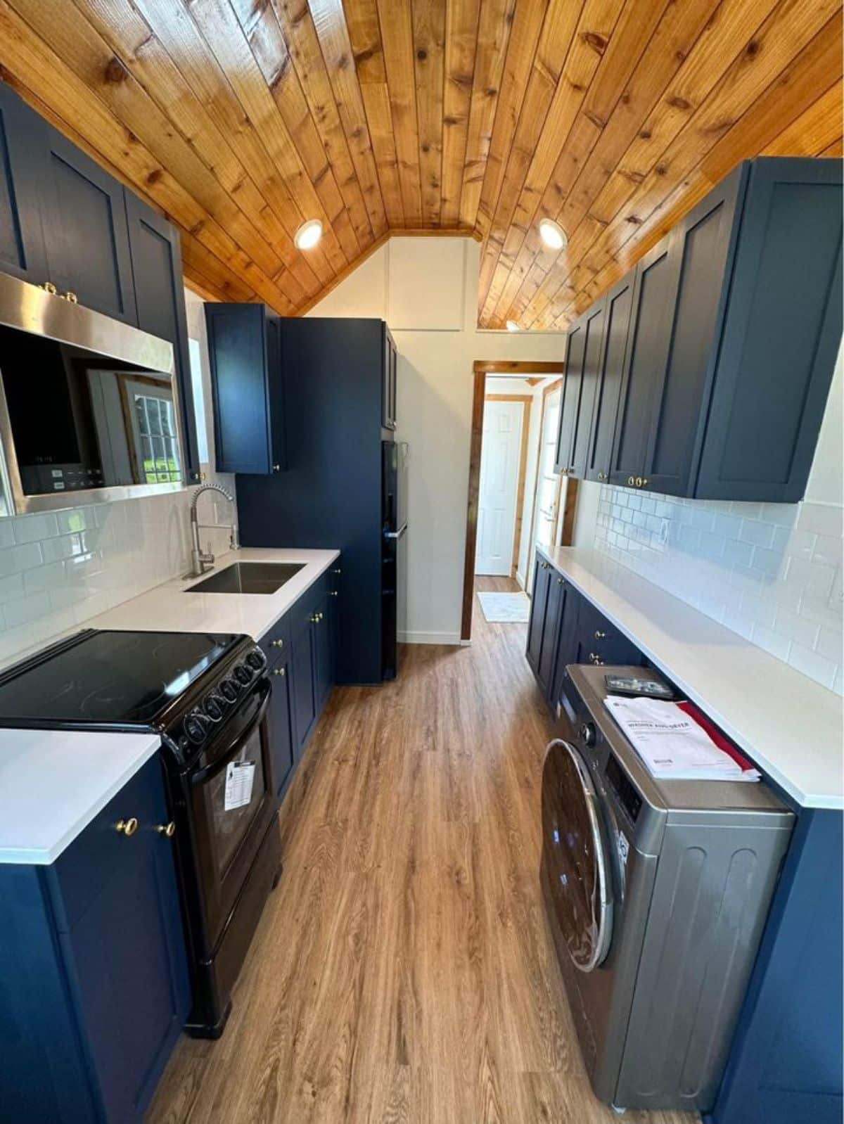 double galley kitchen area with washer dryer placed and storage cabinets