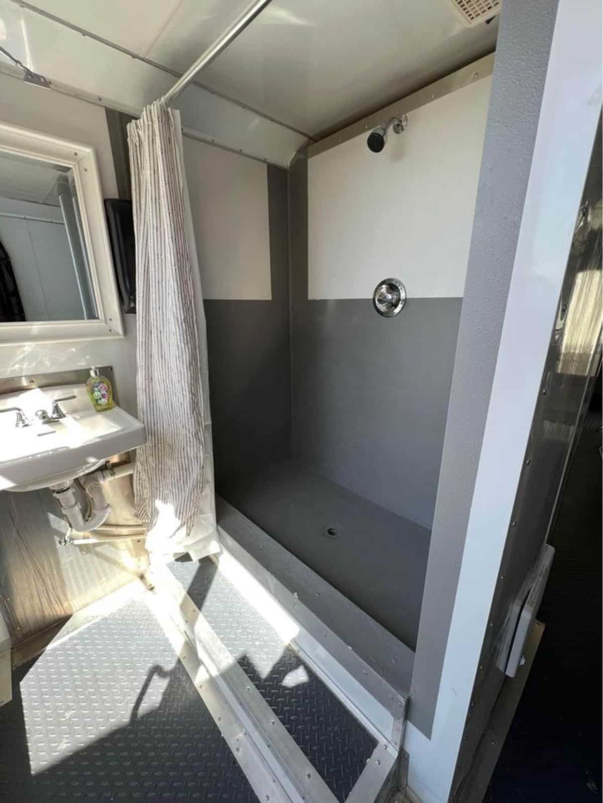 bathroom of tiny trailer home has standard fittings and separate shower area