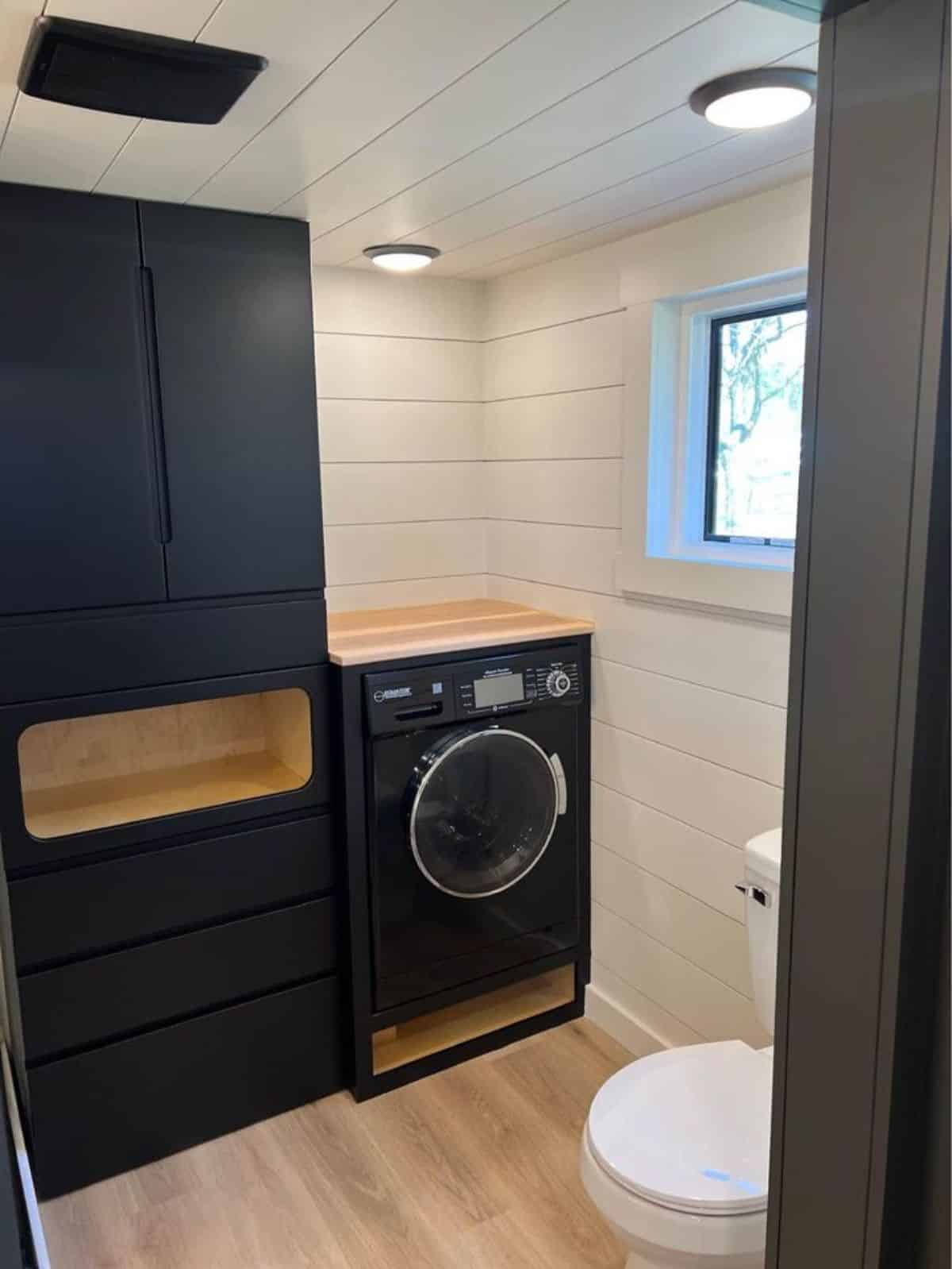 washer dryer combo installed in the bathroom of beautiful tiny home