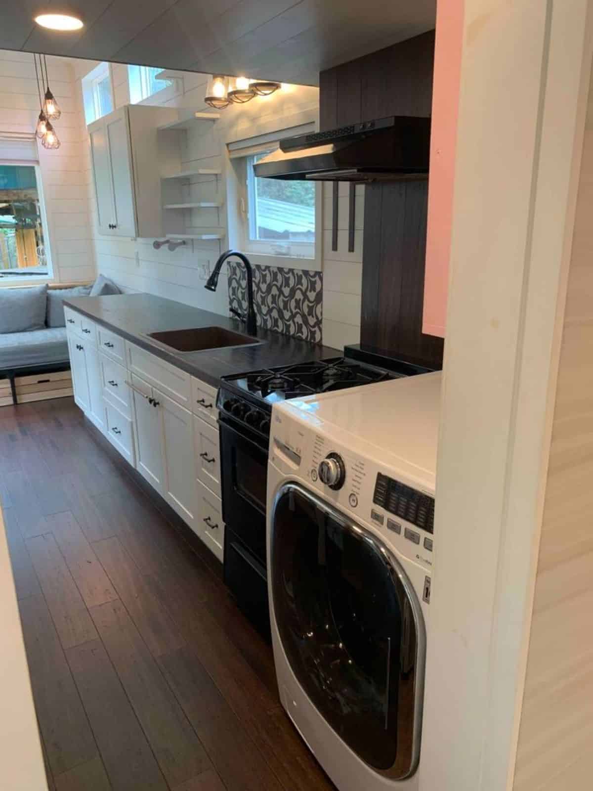 washer dryer right outside the bathroom door of 24’ tiny home with deck