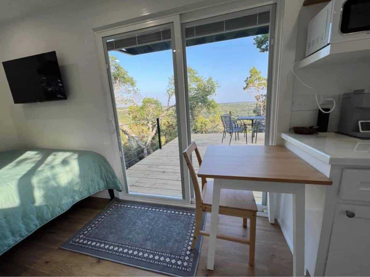 small dining table with chair right besides the main entrance door of affordable tiny home