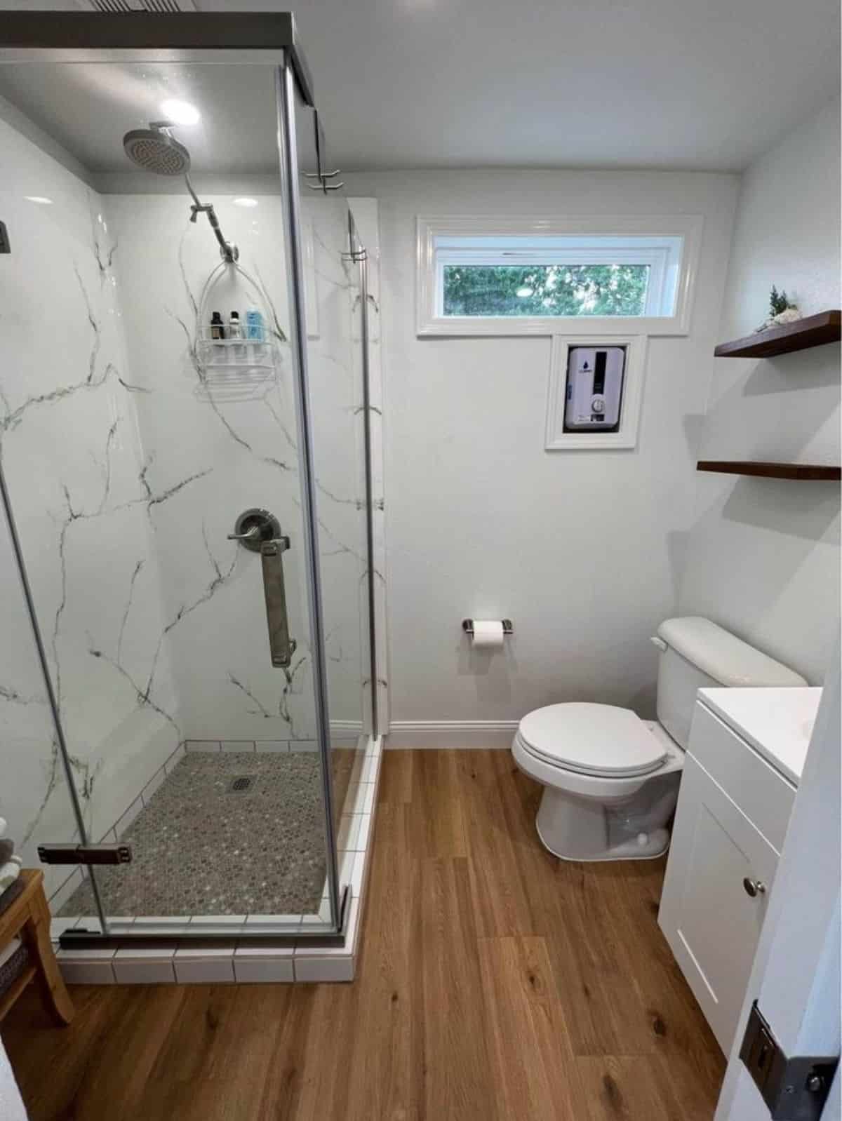 bathroom of affordable tiny home has all the standard fittings and separate shower with glass enclosure