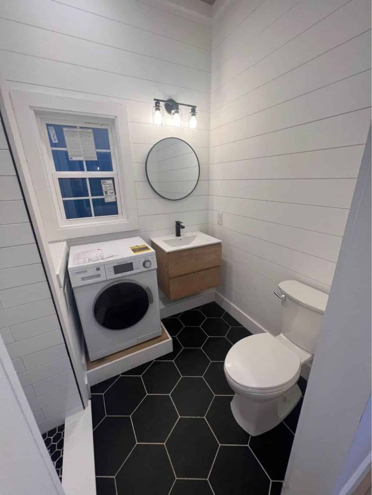 bathroom of brand new 36’ tiny house has all the standard fittings and washer dryer
