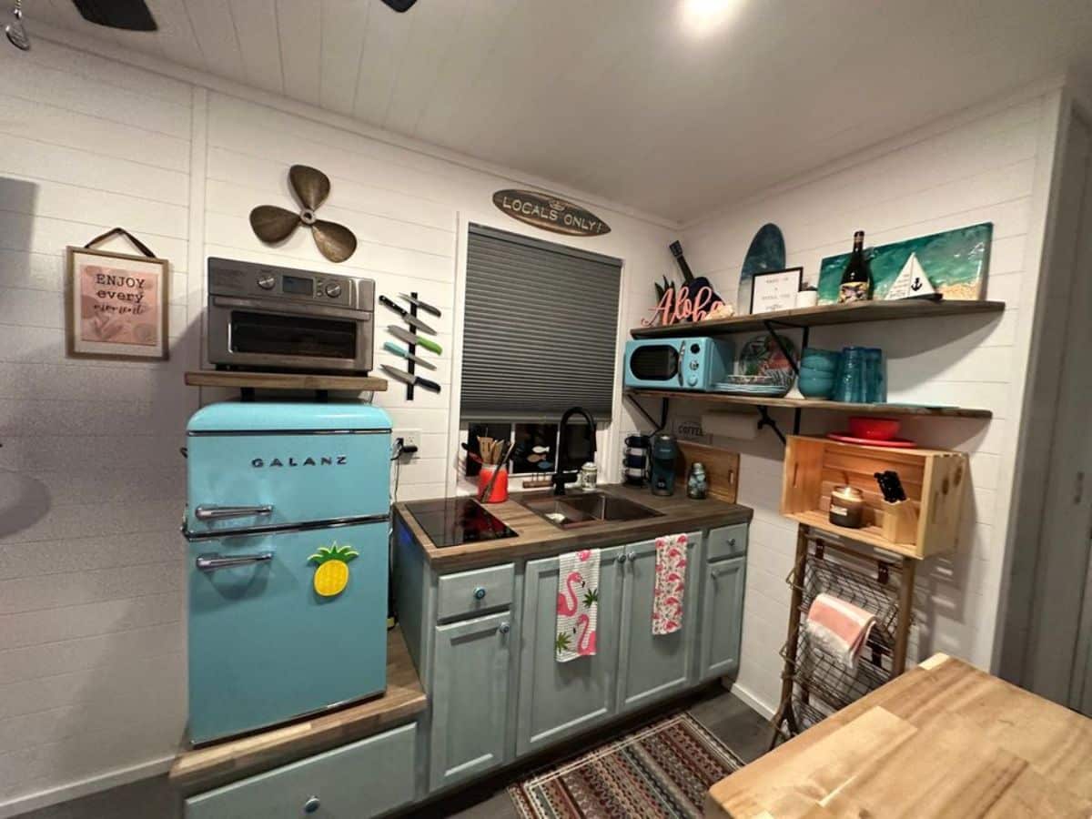 kitchen area of fully furnished 30’ tiny house is small but well organized