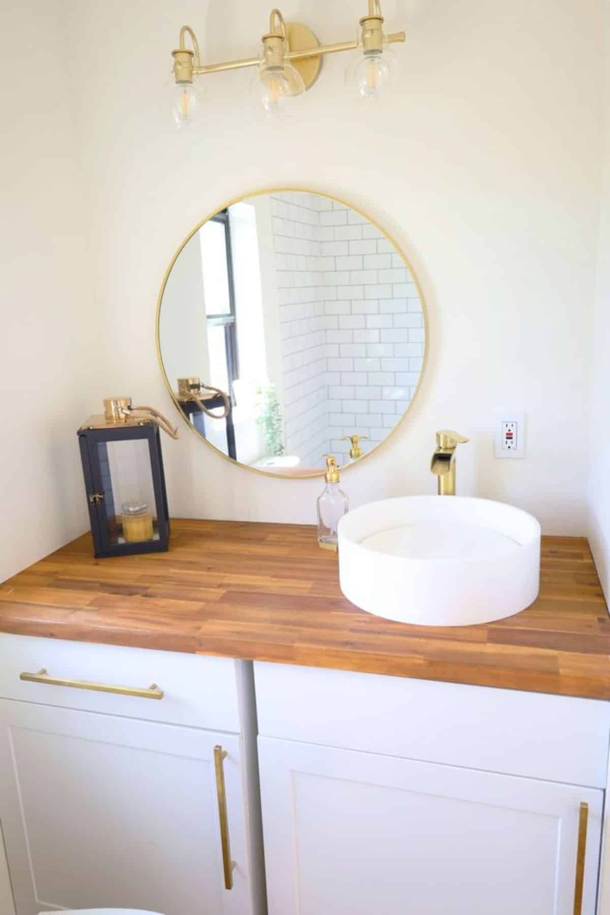 sink with vanity and mirror in bathroom of shipping container tiny home