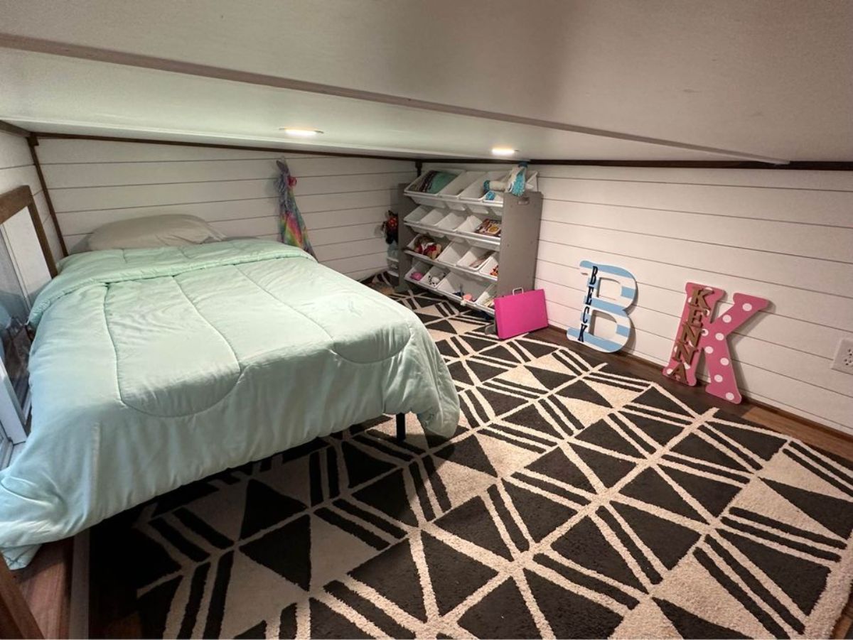 loft 1 of 3 bedroom tiny house  is spacious with comfortable bed and storage