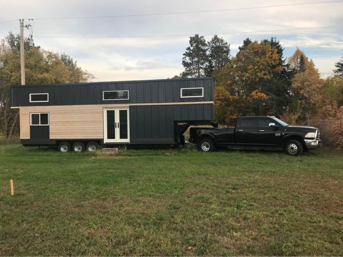 main entrance view of spacious tiny home with car