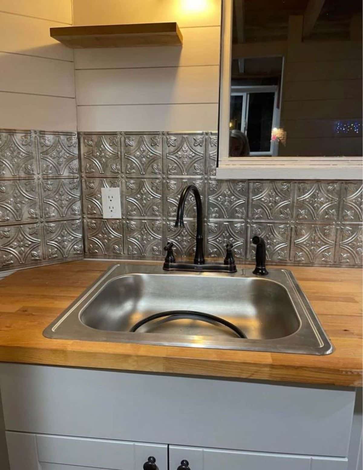 stainless steel sink in the kitchen area of the house