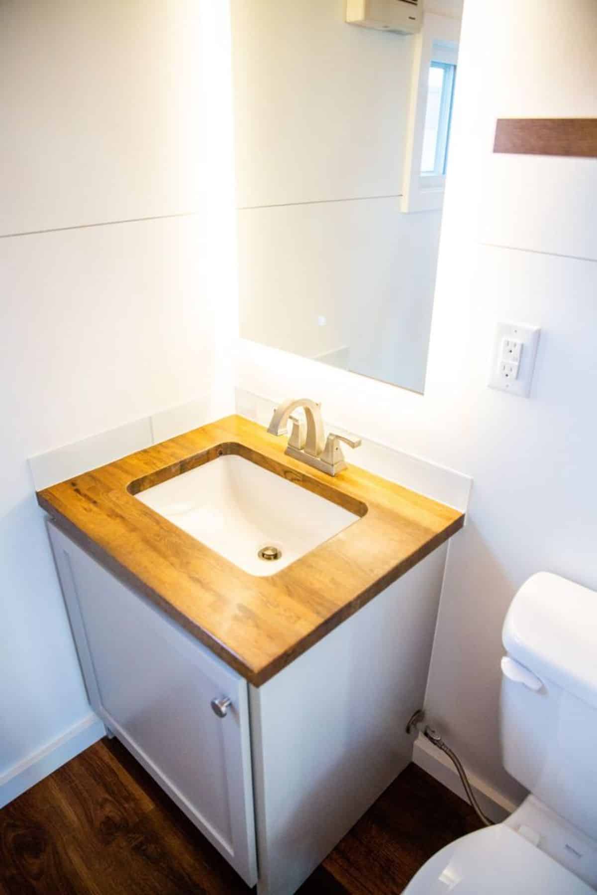 wooden sink with vanity in bathroom