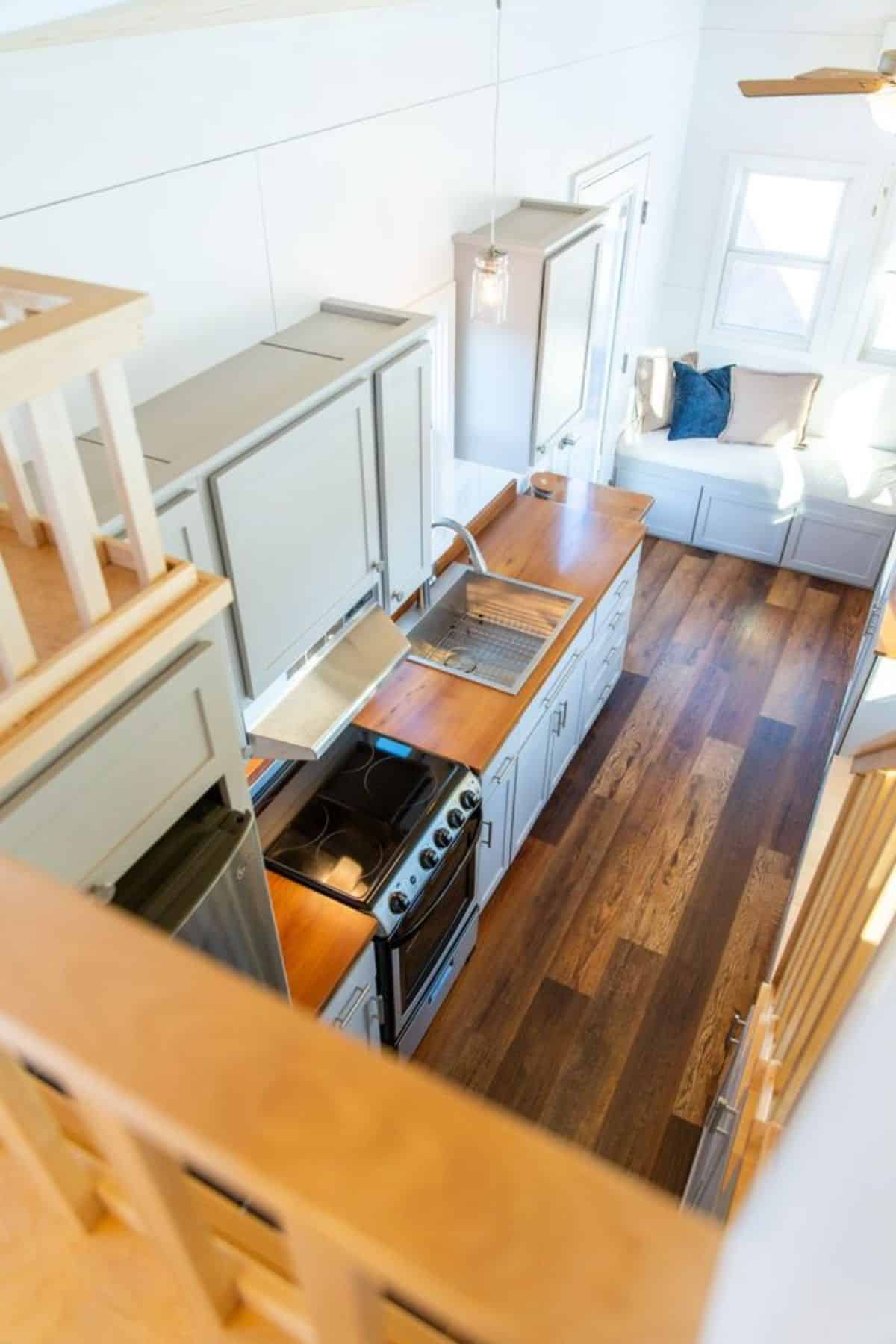 wooden flooring and top view of 24’ tiny house from loft