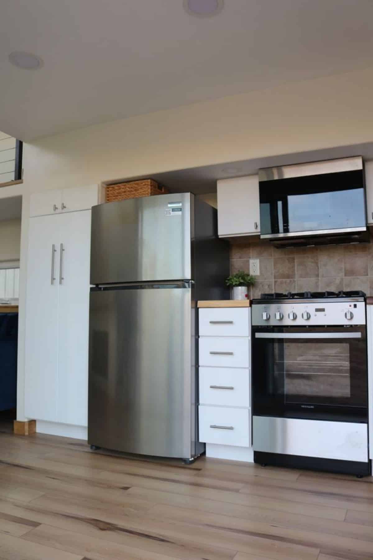 stainless steel refrigerator, 4 burner gas range and storage cabinets included in the kitchen area