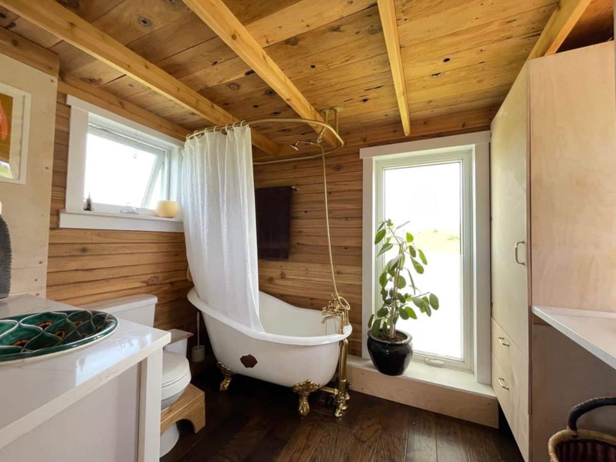 small bathtub besides the window of eco-friendly tiny house