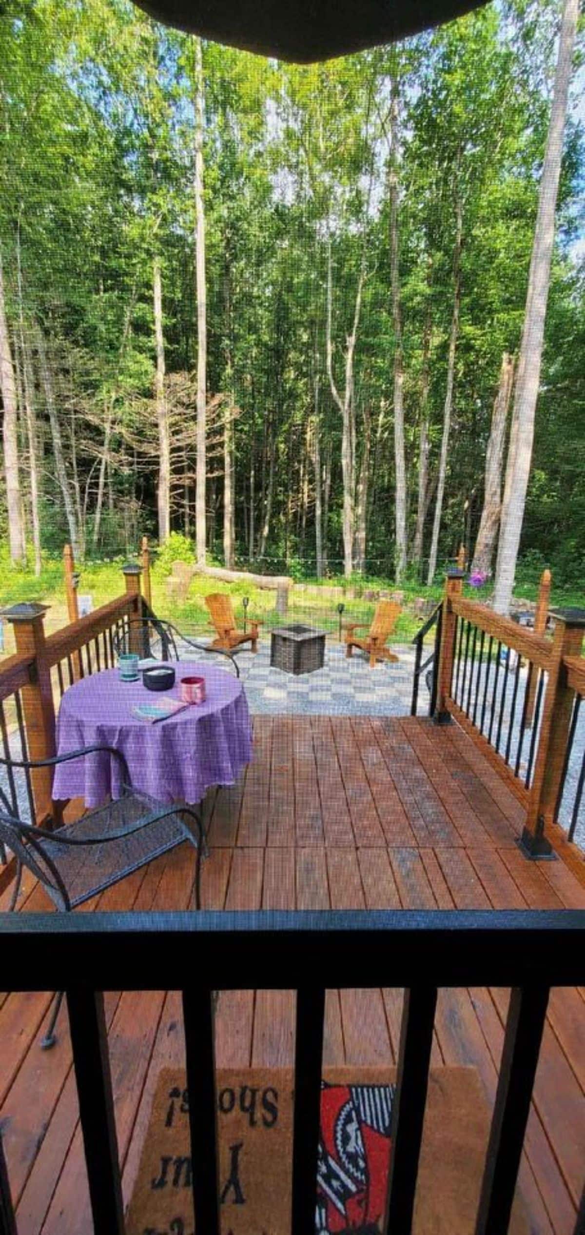 deck outside has a round table and chairs to sit and chill