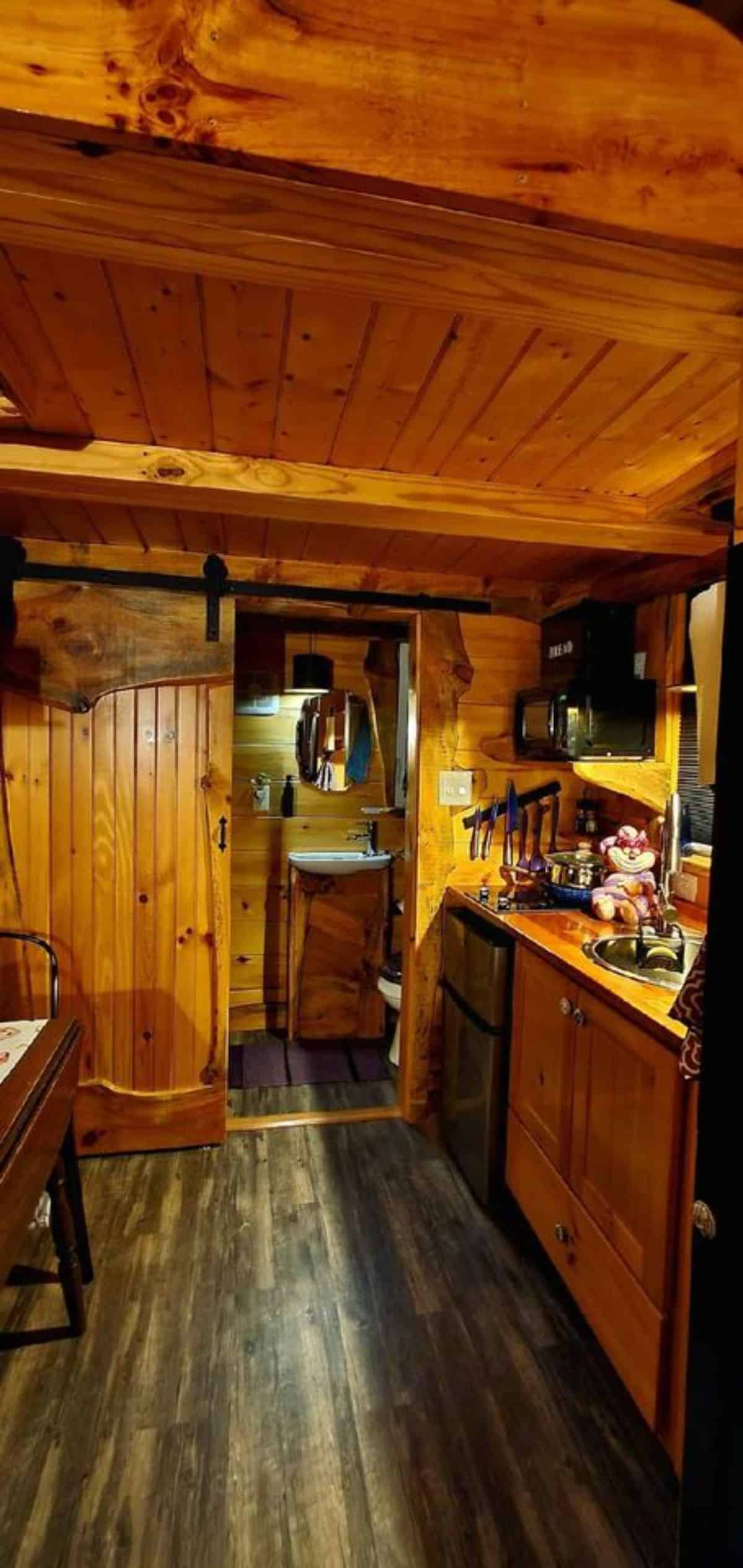 sliding door leading to the bathroom of mad hatter themed tiny house