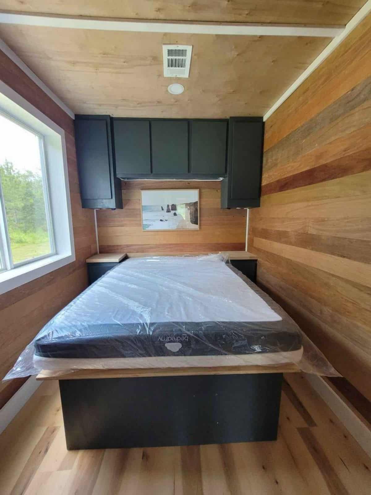 bedroom of affordable 40’ tiny house has a single bed with new matress