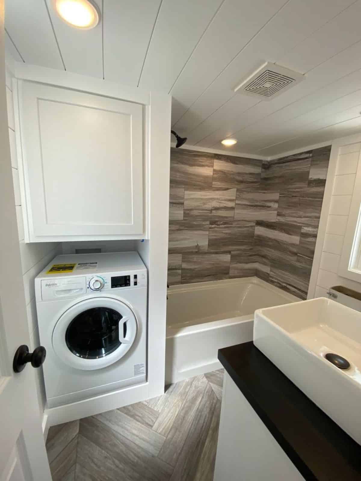 small bathtub and washer dry combo installed in the bathroom
