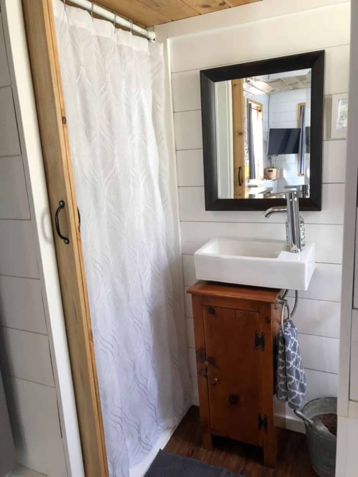 sink with vanity and full length shower area in bathroom