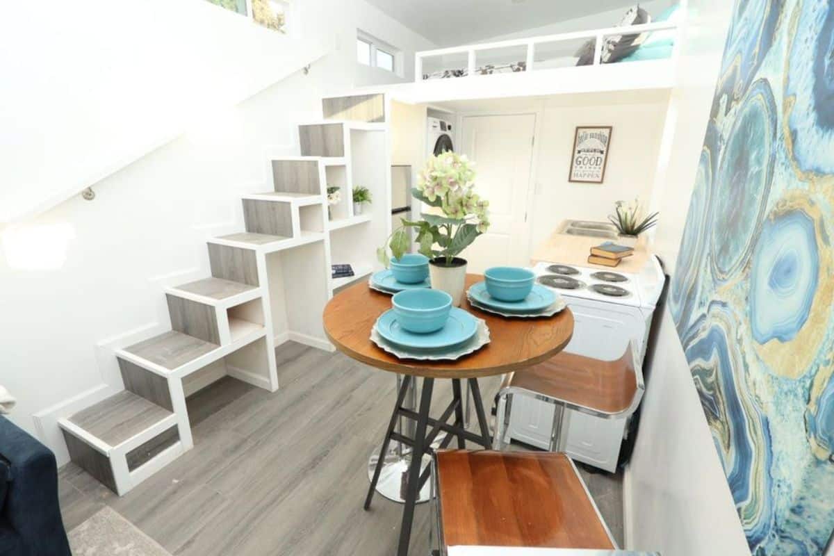 loft 1 is above the bathroom accessible through stairs and round dinning table with chairs